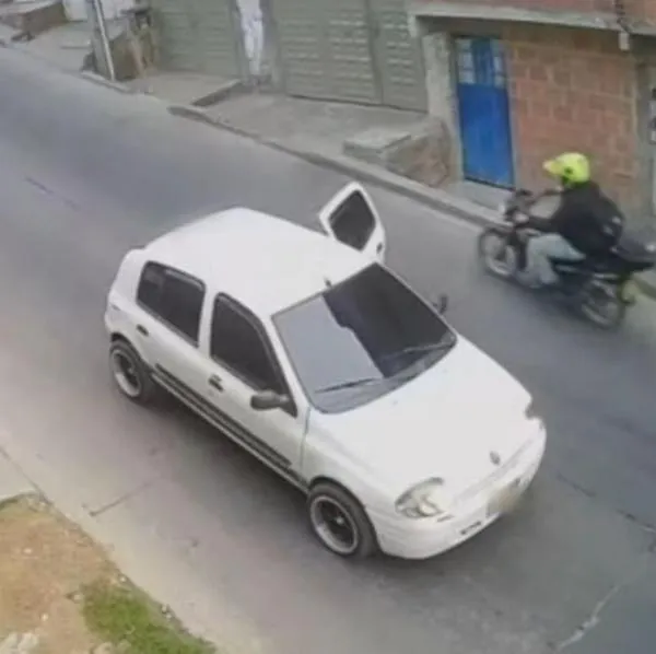 Momento en el que un motociclista pasa cerca de un menor que iba a ser secuestrado por un sujeto que iba en el carro blanco, en Bogotá