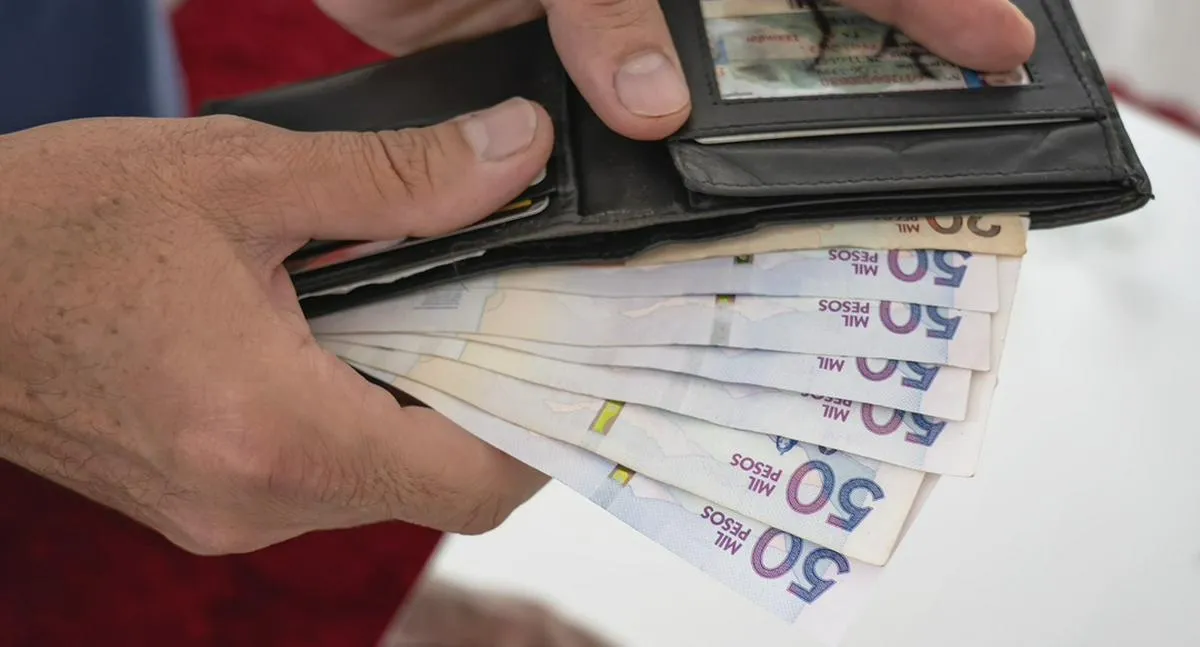 50 thousands pesos bills from Colombia coming out of a man´s  wallet