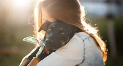 Foto de mujer con perro, en nota de cómo saber si está preparado para adoptar una mascota en Colombia, en test fácil