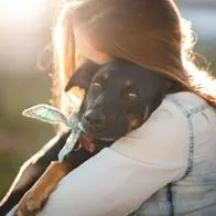 Foto de mujer con perro, en nota de cómo saber si está preparado para adoptar una mascota en Colombia, en test fácil