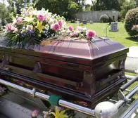 Persona muerta en un ataúd, dentro de un cementerio.