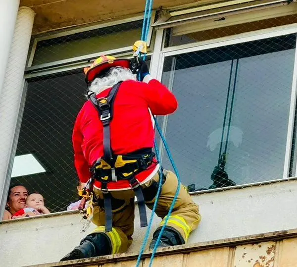 Descolgados por las ventanas, Bomberos alegraron la Navidad de los niños hospitalizados en Medellín