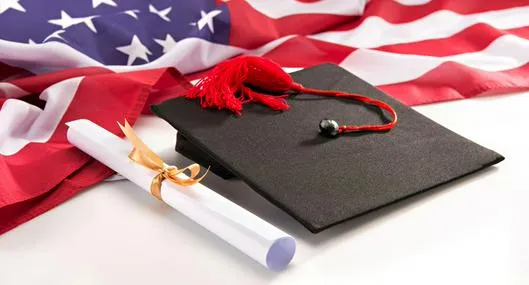 Close-up view of graduation mortarboard, diploma and us flag on white, education concept