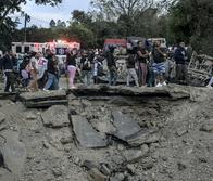 People remain at the site of an explosion after a bomb attack at El Tunel, on the Popayan-Cali road, in Cajibio, Cauca department, Colombia, on April 25, 2026. A bomb attack on April 25 left seven people dead and 20 injured in an area of Colombia with a strong guerrilla presence, amid a spate of attacks just over a month before the presidential elections, the governor of the Cauca region said. (Photo by JOAQUIN SARMIENTO / AFP)