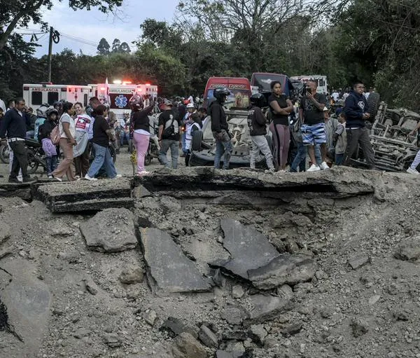 People remain at the site of an explosion after a bomb attack at El Tunel, on the Popayan-Cali road, in Cajibio, Cauca department, Colombia, on April 25, 2026. A bomb attack on April 25 left seven people dead and 20 injured in an area of Colombia with a strong guerrilla presence, amid a spate of attacks just over a month before the presidential elections, the governor of the Cauca region said. (Photo by JOAQUIN SARMIENTO / AFP)