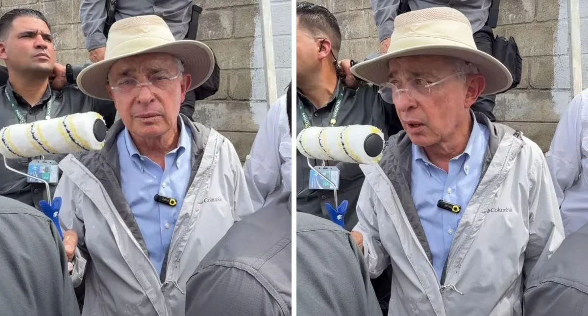 Momento en el que Álvaro Uribe saca un rodillo para pintar un mural sobre falsos positivos que hicieron cerca de su casa