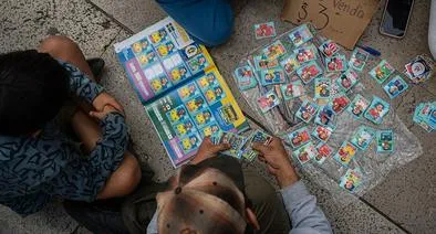 Imagen ilustrativa de gente que intercambia láminas para el álbum Panini de la Copa del Mundo. 
