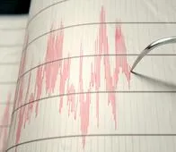 A closeup of a seismograph machine needle drawing a red line on graph paper depicting seismic and eartquake activity - 3D render