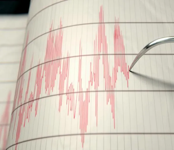 A closeup of a seismograph machine needle drawing a red line on graph paper depicting seismic and eartquake activity - 3D render