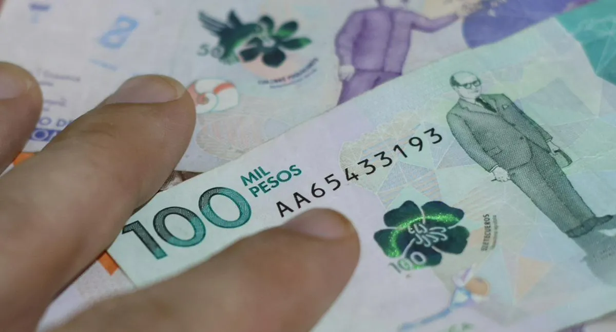 hand on bills, Colombian pesos of different values