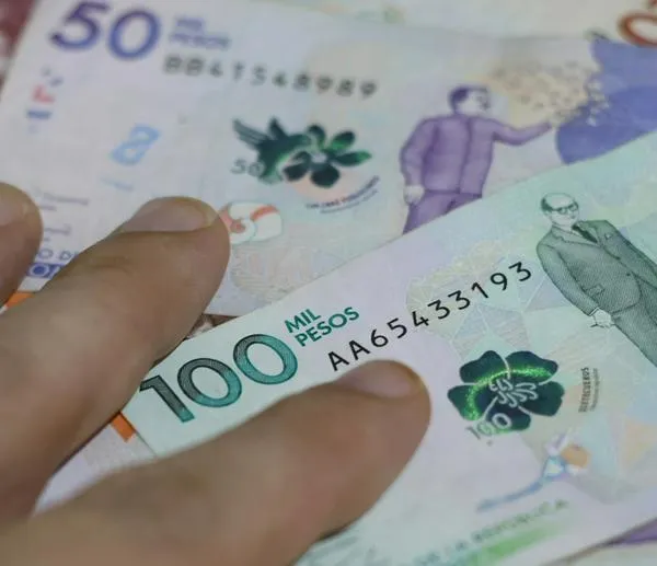 hand on bills, Colombian pesos of different values