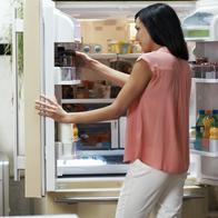 Woman looking in the fridge in her cozy loft apartment
