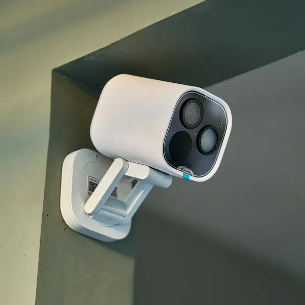 White security camera mounted on a wall, continuously monitoring the room and providing enhanced safety and surveillance through cutting-edge technology and smart design