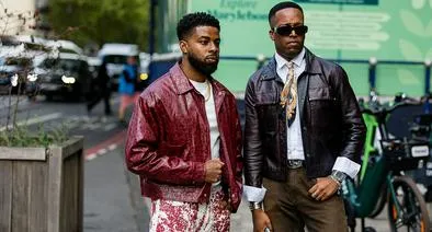LONDON, ENGLAND - SEPTEMBER 17: A guest (L) wears a red distressed leather jacket, a white t-shirt, red and white splatter pattern trousers, and a gold chain outside Mark Fast on September 17, 2026 in London, England. (Photo by Christian Vierig/Getty Images)