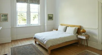 Wooden bed by window in bedroom at home