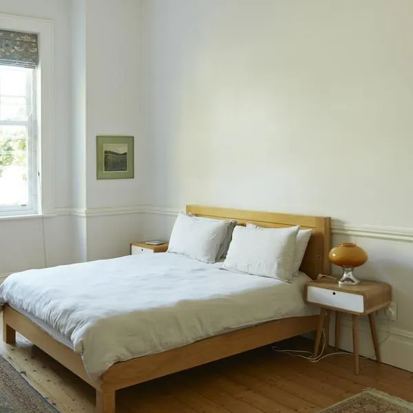 Wooden bed by window in bedroom at home