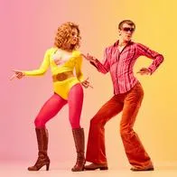Rhythm and swing. Young stylish emotional man and woman, professional dancers in retro style clothes dancing disco dance over pink-yellow background. 1970s, 1980s fashion, music concept