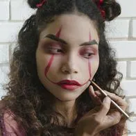 Woman Putting On Evil Clown Makeup
