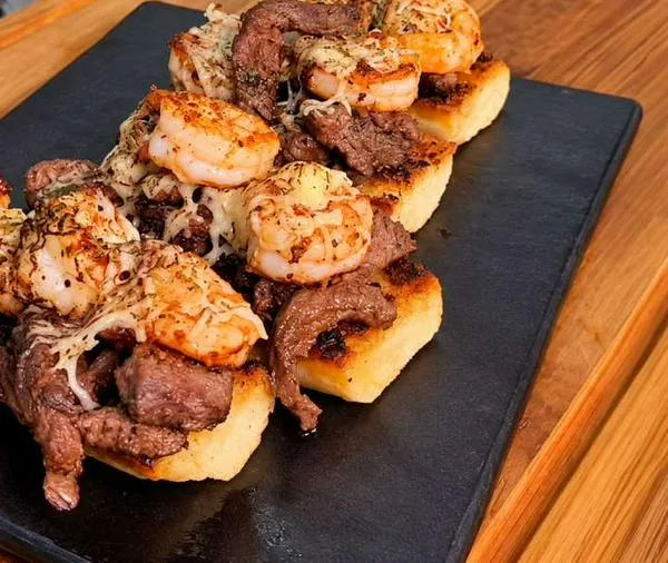 Receta para hacer tostadas mar y tierra con carne y camarones para compartir
