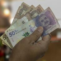 Money from Colombia, Man holding peso bills in front of him, Business investments, Creative financial concept