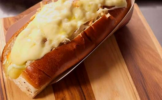 Cómo se prepara el perro caliente americano con pollo y queso mozzarella y cuál es su origen histórico