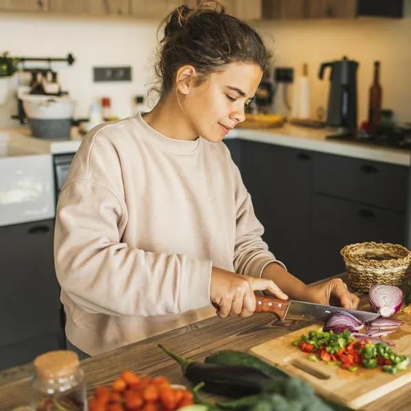 Fresh and healthy raw organic food. Farm vegetables. Vegetarian meal preparation. Young pretty woman cooking at home.