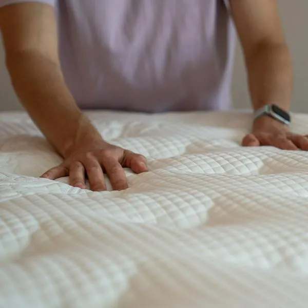 Man hands feeling new orthopedic mattress assessing comfort firmness material quality for back pain. Back support, spinal alignment pressure relief, ergonomic design, durable surface, sleep health