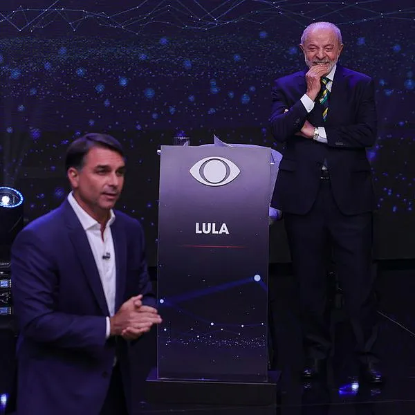 Lula da Silva (atrás) y Flávio Bolsonaro (adelante) durante un debate de las elecciones presidenciales de Brasil