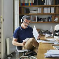 Mature businessman examining documents at desk in office
