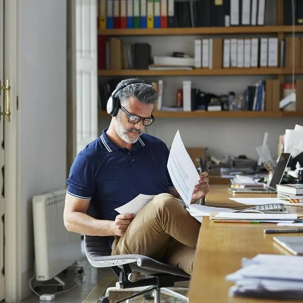 Mature businessman examining documents at desk in office