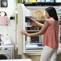 Woman looking in the fridge in her cozy loft apartment