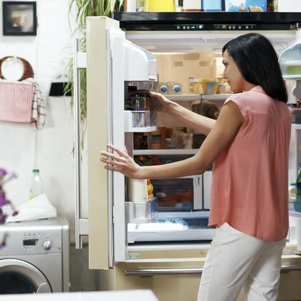 Woman looking in the fridge in her cozy loft apartment